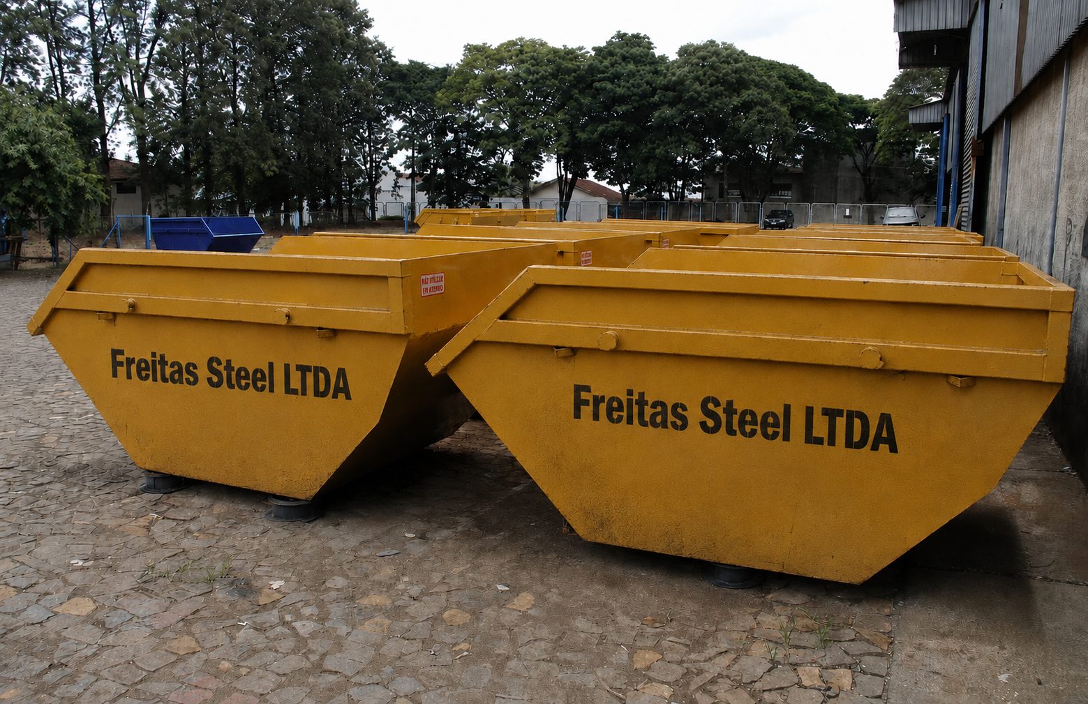 Caçambas estacionárias amarelas da Freitas Steel LTDA no pátio da empresa
